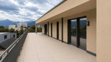 Weitläufige Terrasse mit Panoramablick über die Stadt und die umliegende Landschaft unter bewölktem Himmel.