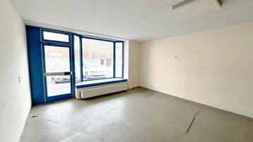Geräumiger, leerer Gewerberaum mit großen Schaufenstern und viel Tageslicht zur Straße.
