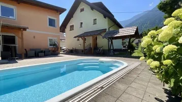 Blauer Swimmingpool im Außenbereich mit Blick auf die umliegenden Berge.
