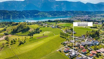 Luftaufnahme der Wohngegend mit See, Bergen und umliegender Natur.
