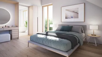 Helles Schlafzimmer mit Holzboden, Schminktisch und Zugang zu einem angrenzenden Badezimmer.