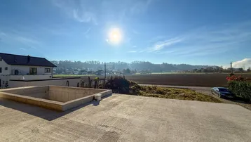 Große Betonfläche im Außenbereich mit weitem Blick über die sonnige Landschaft.