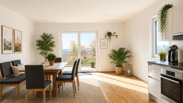 Helles Wohn- und Esszimmer mit Holzboden, moderner Einrichtung und Zugang zu einem Balkon mit Weitblick.