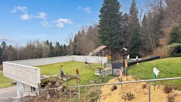 Gepflegter Gartenbereich mit Rasenfläche, Dekorationen und Blick auf die umliegende Natur.