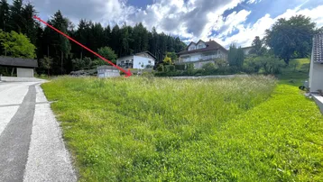 Großes, sonniges Grundstück mit Blick auf umliegende Häuser und Waldrand.