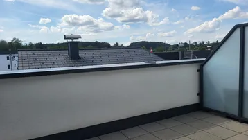 Geräumige Dachterrasse mit Fliesenboden und weitem Blick über die Dächer.