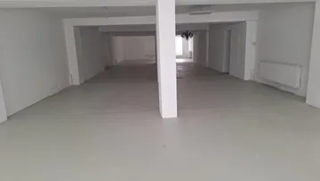 Großer, leerer Gewerberaum mit weißen Wänden und Säulen, bereit für den Ausbau.