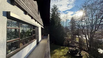Langer Balkon mit Blick ins Grüne und auf die umliegende Landschaft, ideal für sonnige Tage.