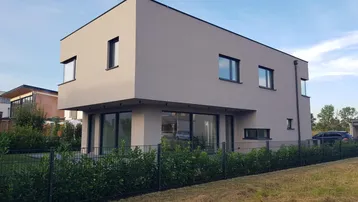 Modernes Einfamilienhaus mit klarer Architektur, großen Fensterfronten und gepflegtem Vorgarten.