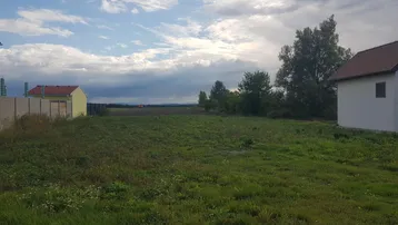Weitläufiges Grundstück mit grüner Wiese und Blick auf die umliegende Landschaft und Häuser.