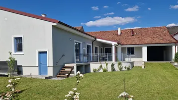 Geräumiger Gartenbereich mit Rasenfläche und einer erhöhten Terrasse, ideal für Entspannung im Freien.