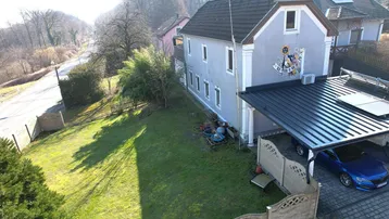 Luftaufnahme des Hauses mit Garten, Carport und Solaranlage an einem sonnigen Tag.