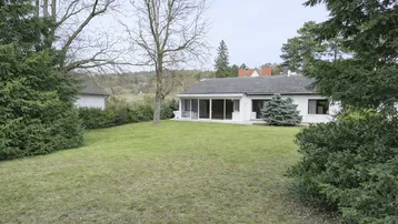Großzügiger Gartenbereich mit Rasenfläche und Blick auf das Einfamilienhaus mit Wintergarten.