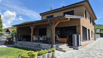 Großzügige überdachte Terrasse mit Sitzbereich und Blick auf den gepflegten Garten.