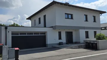 Modernes Einfamilienhaus mit integrierter Garage und barrierefreiem Zugang.