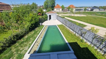 Blick von oben auf den Garten mit Pool, einem kleinen Schuppen und einem angrenzenden Spielplatz.