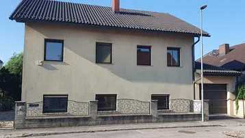 Einfamilienhaus mit klassischer Fassade, Satteldach und Vorgartenbereich.
