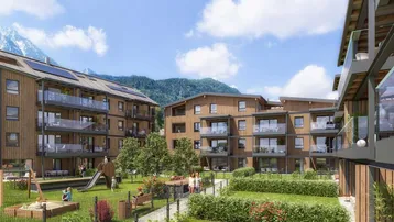 Moderne Wohngebäude mit Holzfassaden, Balkonen, Spielplatz und Bergblick in einer grünen Umgebung.