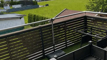 Balkon mit Kunstrasen, Outdoor-Möbeln und Bergblick auf die umliegende Landschaft.