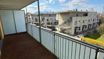 Geräumiger Balkon mit Holzboden und Bergblick, perfekt für entspannte Stunden im Freien.