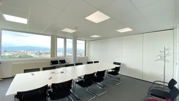 Großer Konferenzraum mit weitem Stadtblick und modernen Büromöbeln für Besprechungen.
