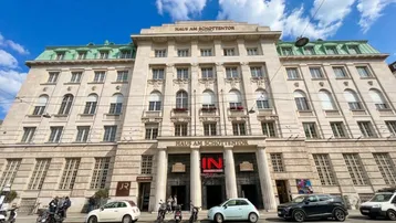 Eindrucksvolle Fassade des historischen Gebäudes 'Haus am Schottentor' mit klassischer Architektur und Blick auf die Straße.