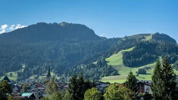 Panoramablick auf eine malerische Berglandschaft mit einem Dorf im Tal.