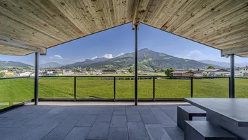 Große Terrasse mit Fliesenboden und atemberaubendem Bergblick, ideal für Entspannung im Freien.