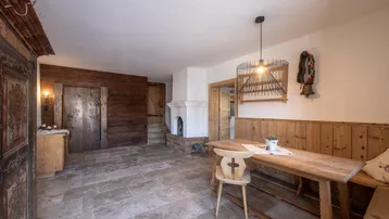 Gemütlicher Essbereich mit Fliesenboden, Kamin und traditionellen Holzmöbeln.