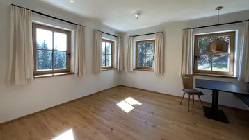 Geräumiger Wohnbereich mit vielen Fenstern, die einen schönen Blick ins Grüne bieten und viel Licht hereinlassen.