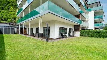 Moderne Wohnanlage mit großzügiger Terrasse und direktem Zugang zum gepflegten Rasenbereich.