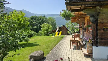 Gemütliche Terrasse mit Sitzgelegenheiten, Grillplatz und weitem Blick auf die umliegende Berglandschaft.