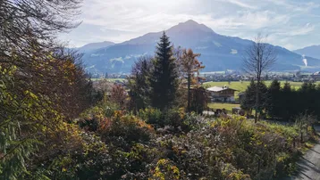 Panoramablick auf die umliegende Berglandschaft und ein malerisches Tal mit Dorf.