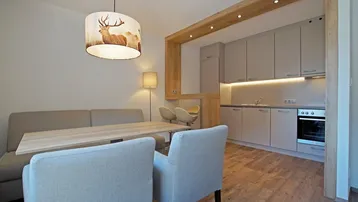 Offener Wohn- und Essbereich mit integrierter Küche, Holzakzenten und modernem Design.