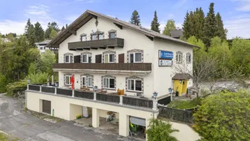 Traditionelles Gasthaus mit mehreren Balkonen und einer großen Terrasse im ländlichen Stil.