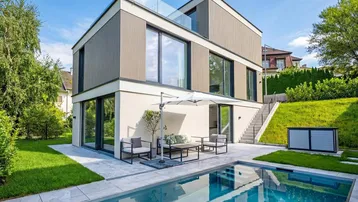 Modernes Einfamilienhaus mit großzügiger Terrasse, Swimmingpool und gepflegtem Gartenbereich.