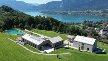 Moderne Immobilienanlage mit mehreren Gebäuden, einem Naturteich und atemberaubendem See- und Bergblick.