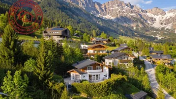 Panoramablick auf ein charmantes Bergdorf mit traditionellen und modernen Häusern in alpiner Landschaft.