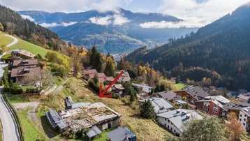 Luftaufnahme eines Grundstücks in den Bergen mit Blick auf einen See und umliegende Häuser.