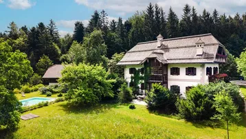 Großzügiges Anwesen mit traditionellem Haus, weitläufigem Garten und privatem Pool, umgeben von Wald.