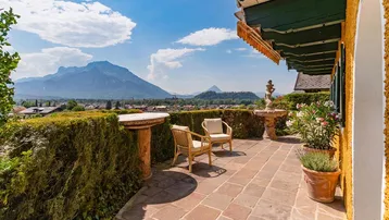 Große Terrasse mit Sitzgelegenheiten, Brunnen und einem weiten Blick auf die Berge und die Landschaft.