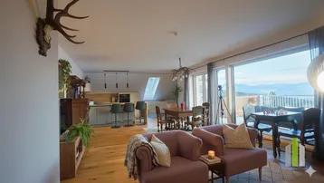 Geräumiger offener Wohn- und Essbereich mit integrierter Küche und Panoramablick auf die Berge.