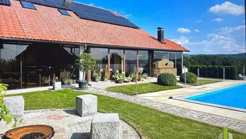 Großzügiger Außenbereich mit Pool, Liegewiese, Feuerstelle und Solaranlage auf dem Dach.