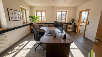 Geräumiges Büro mit großem Holzschreibtisch, Holzboden und mehreren Fenstern, die viel Tageslicht hereinlassen.