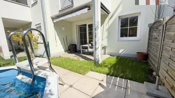 Terrasse mit kleinem Pool und Rasenfläche, direkt am Gebäude gelegen, ideal für Entspannung.