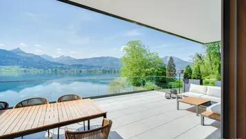 Große, möblierte Terrasse mit atemberaubendem Blick auf den See und die umliegenden Berge.