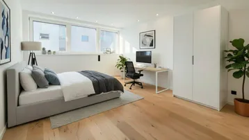 Helles Schlafzimmer mit Holzboden, großem Fenster und integriertem Arbeitsbereich in modernem Stil.