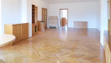Geräumiges, helles Wohnzimmer mit Fischgrätparkett und Holzmöbeln, bereit zur individuellen Gestaltung.