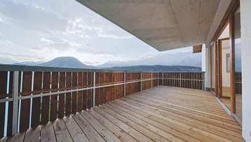 Großer Balkon mit Holzboden und atemberaubendem Panoramablick auf die Berge.