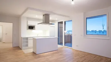 Heller offener Wohn-Essbereich mit moderner Einbauküche, Kochinsel und Zugang zum Balkon.